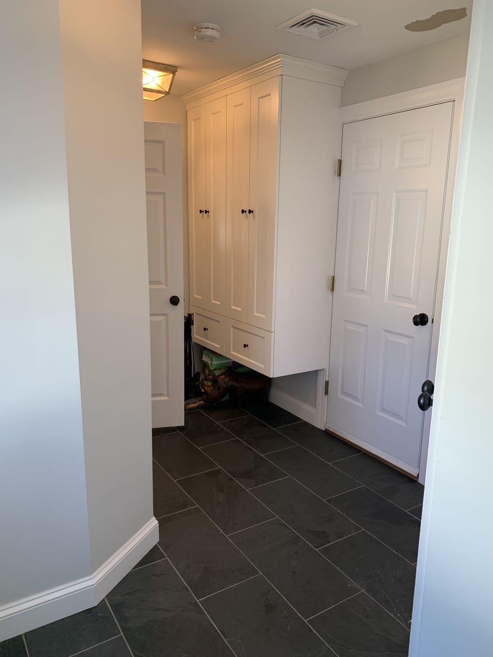Beautiful black slate floors in the mudroom with plenty of storage and hanging