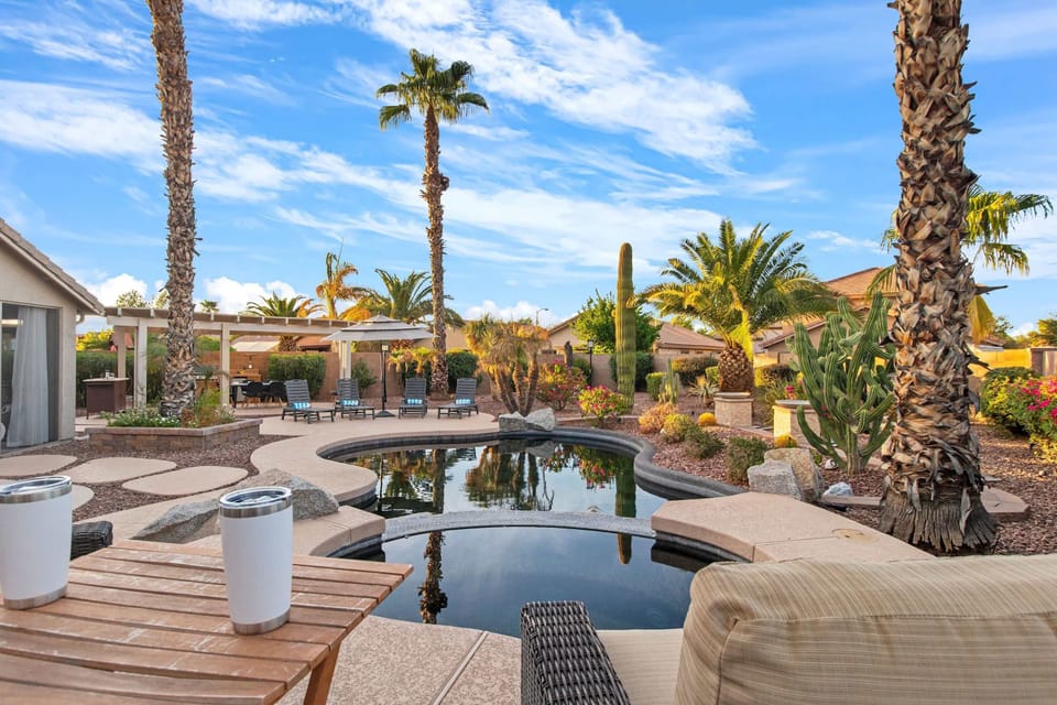 Tropical backyard oasis with a serene pool, palm trees, and comfortable outdoor seating.