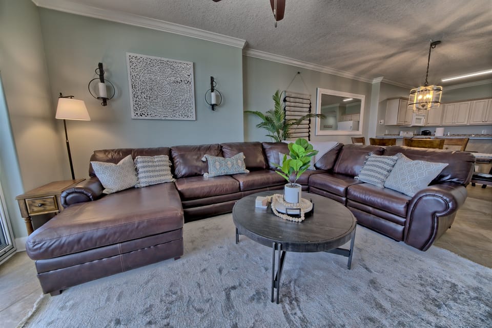 Living room has a comfortable sectional with a reclining chair on the end and a sleeper sofa
