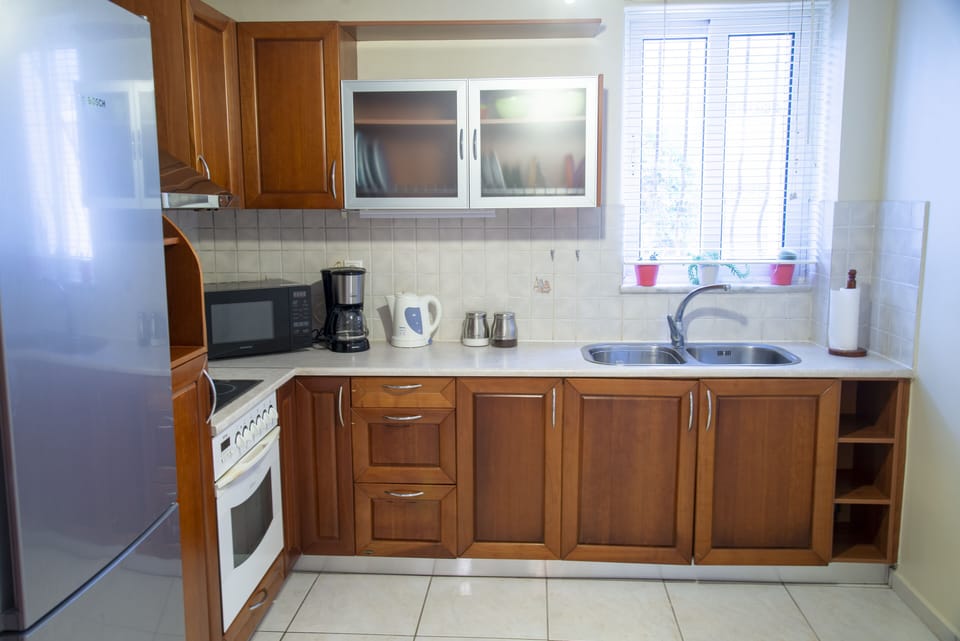Fully equipped kitchen with stove, oven, fridge, coffee machine, and kettle.