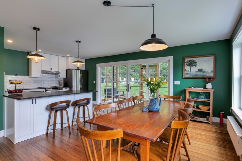 The dining area sits beside the kitchen, with sliding doors leading to the screened porch