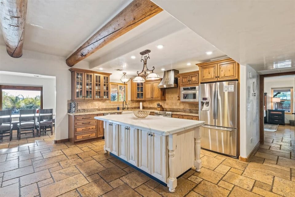At the heart of the room, the spacious kitchen island doubles as a prep area and a gathering spot, perfect for chatting with friends and family while you cook.