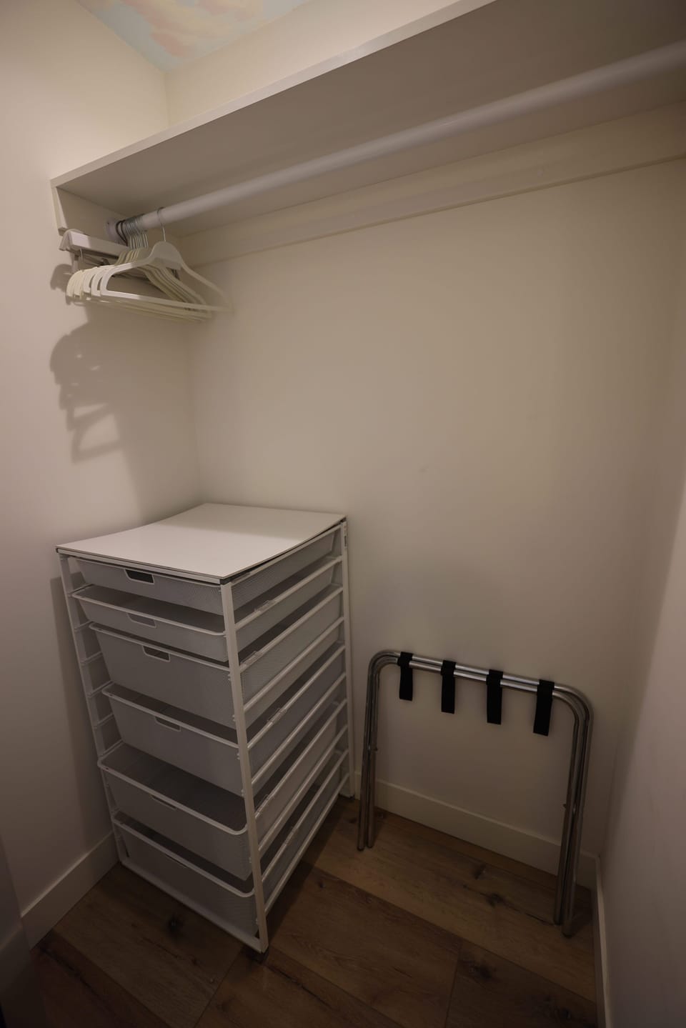 Tiki twin bedroom closet with hangers, luggage rack and drawers