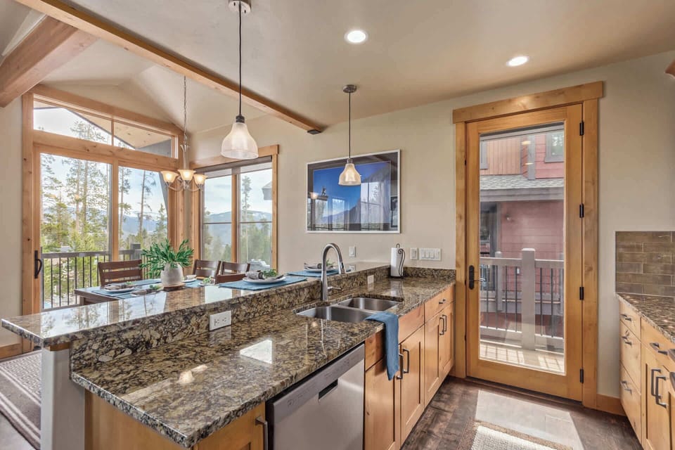 This charming kitchen boasts stainless steel appliances, a convenient bar/serving area with seating for four that connects to the dining room space and access to a patio.