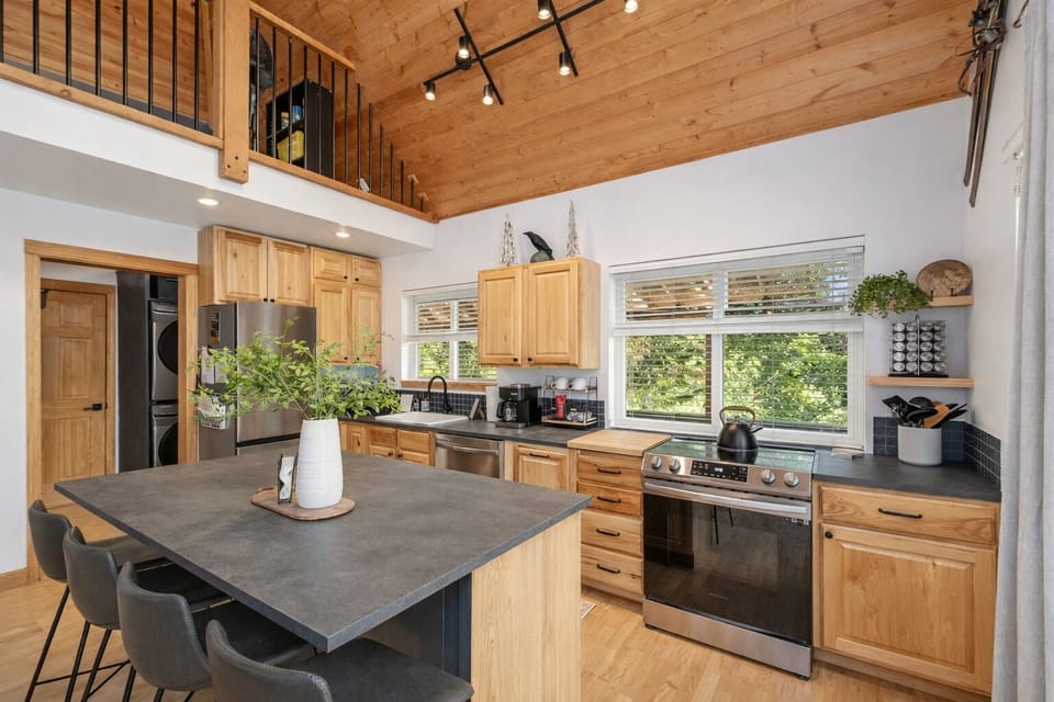 Cook your favorite meals in this bright, open kitchen featuring sleek countertops and modern appliances surrounded by warm wood details.