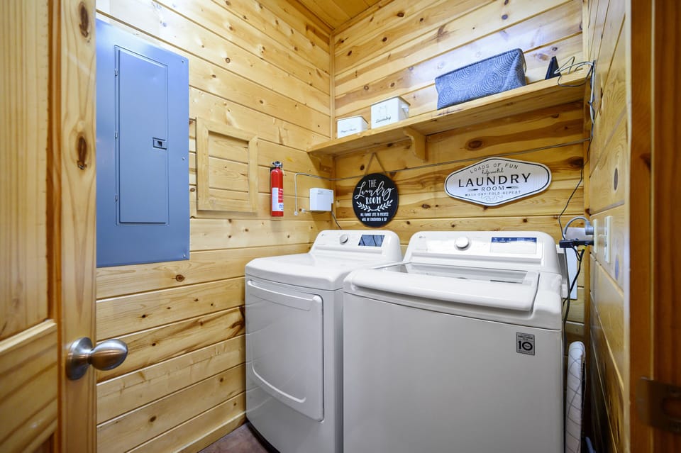 Utility room with vacuum, brooms and full size washer and dryer 