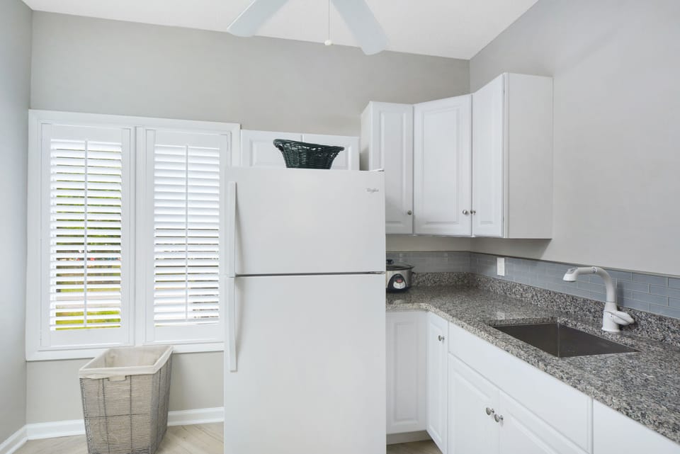 Butler’s Pantry with Extra Counter Space - Located just off the kitchen and laundry room, this butler’s pantry offers extra prep space, a second sink, and natural light from the side yard—perfect for staging groceries or storing beach snacks.
