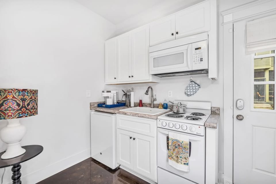 The property includes a full kitchenette with a range/oven, fridge + microwave