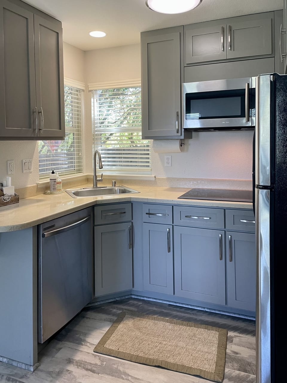 Kitchenette with cooktop, microwave, toaster oven, dishwasher and refrigerator.