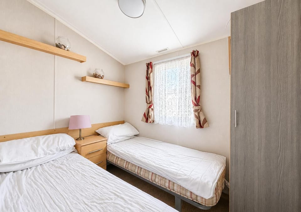 Practical twin caravan bedroom, designed to offer comfort and functionality for your UK travels!