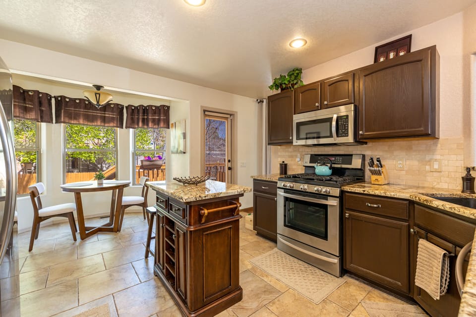Kitchen has stainless steel appliances, granite counters and a breakfast nook.