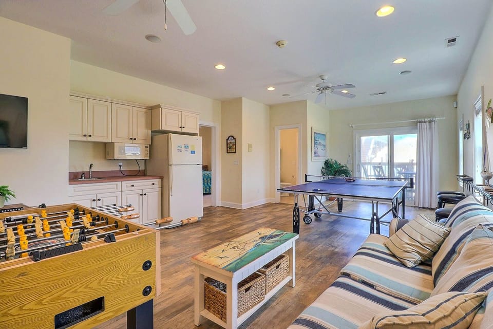 When you're done playing and relaxing outside, enter into the ground level to find the first of two amazing game rooms with a TV viewing area, ping pong table, foosball, a wet bar with a full-size refrigerator for chilling drinks for the beach and the pool, and a microwave for lunch and snack prep.