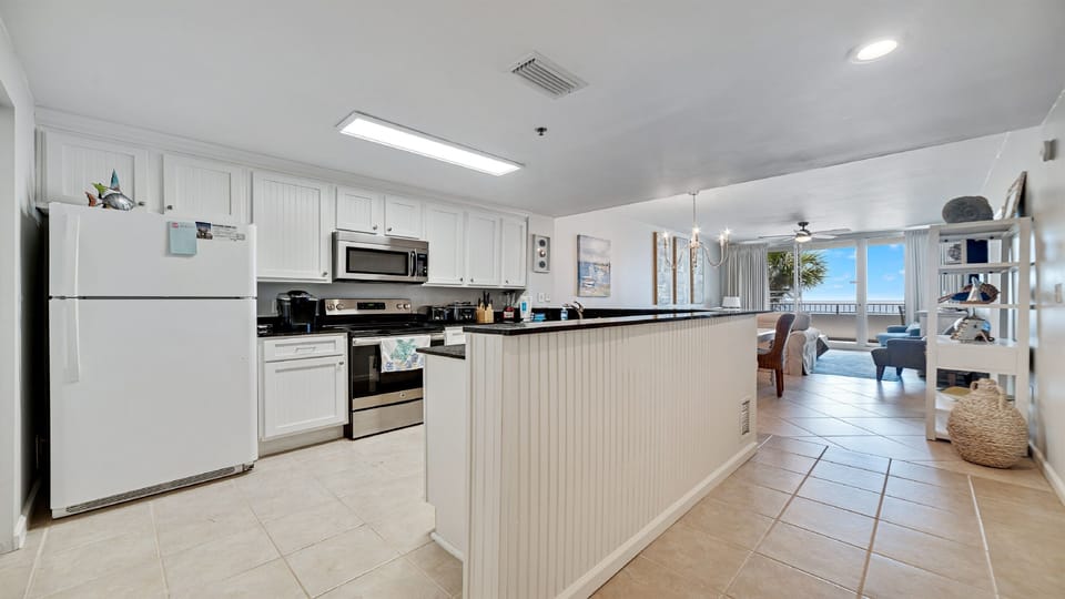 This fully functional kitchen boasts stainless steel appliances, sleek countertops, a decorative backsplash, and ample cabinet storage, ideal for everyday cooking and entertaining.
