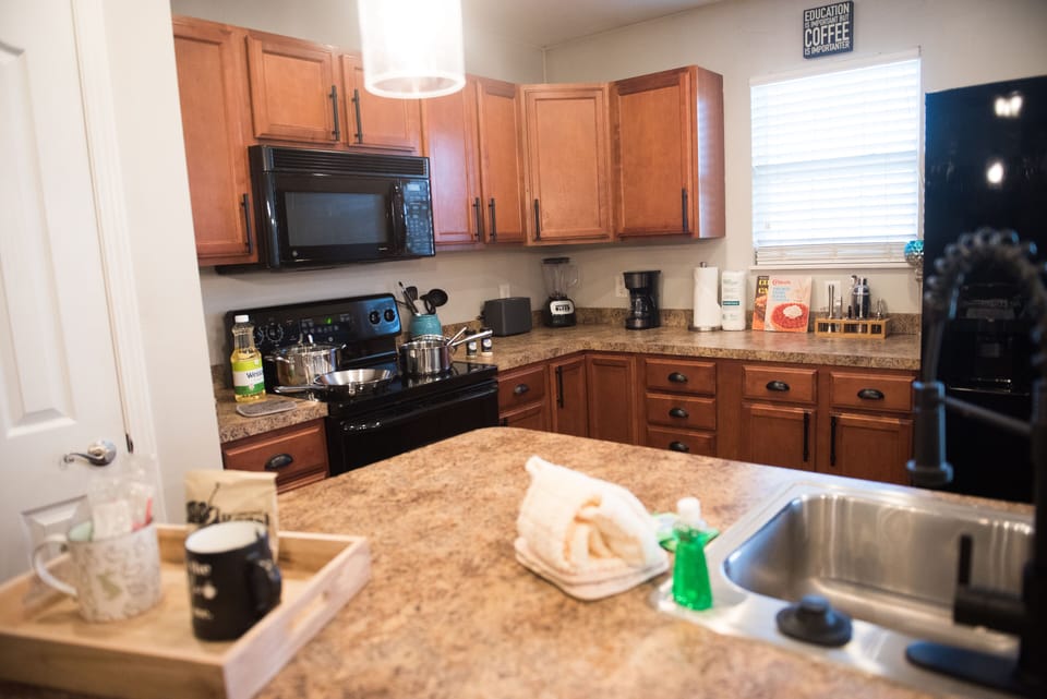 Stocked kitchen with starter supplies and cookware. Full-size appliances.