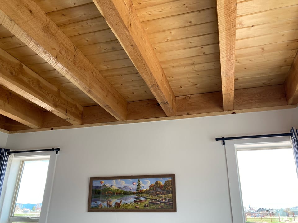 King bedroom with open beams and tongue and groove pine ceiling
