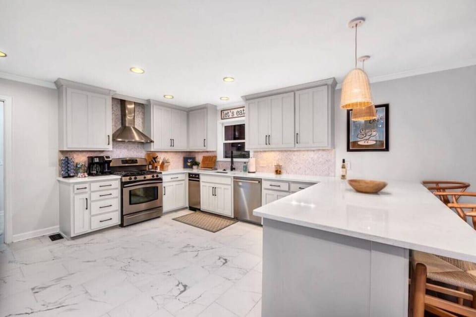 Kitchen fully stocked with all cooking essentials, oven, bar area, dishwasher, microwave, stove and drop coffee maker