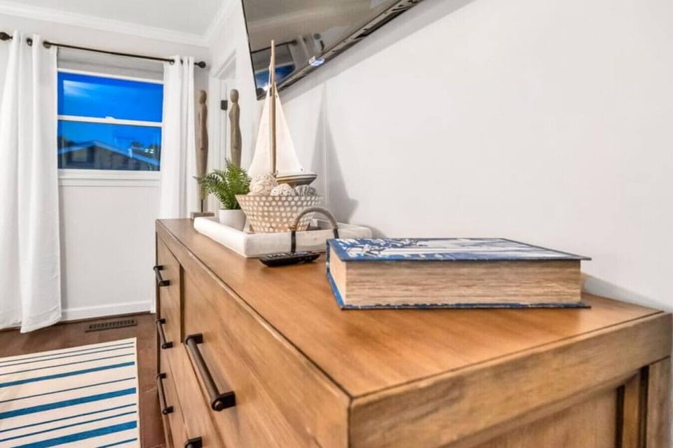 TV mounted above dresser in master bedroom