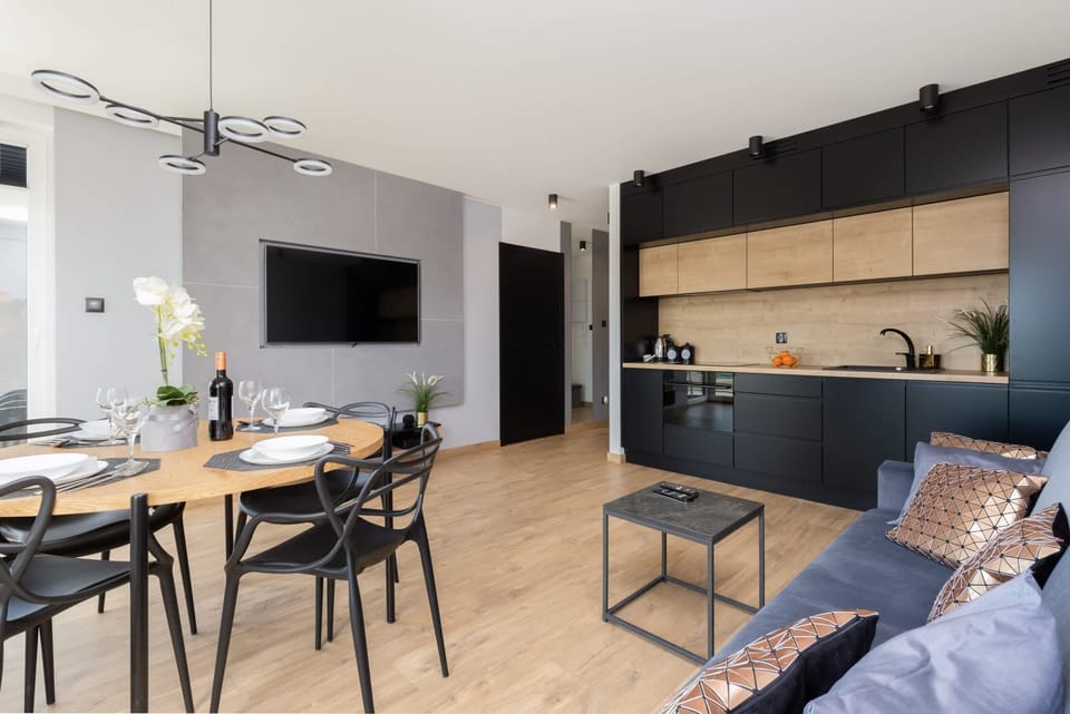 Another angle of the open-plan area, showcasing the seamless integration of the kitchen, dining, and living spaces. Contemporary furniture and decor create a cohesive look.