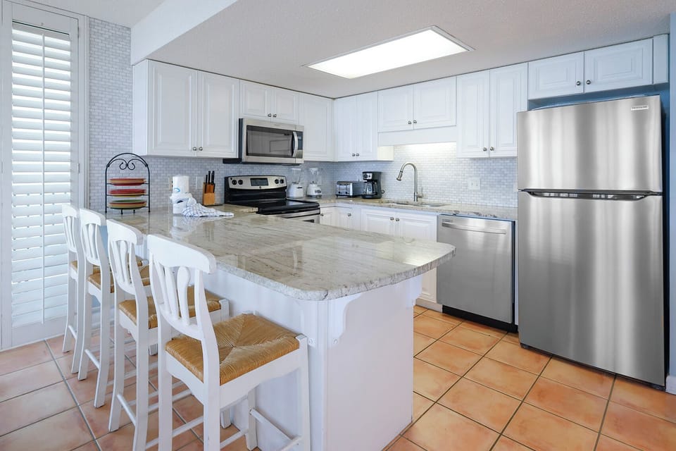 Gather around the spacious kitchen bar with seating, perfect for casual meals and conversation in a welcoming space