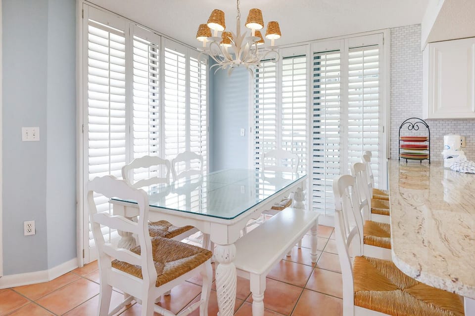Gather around the spacious glass dining table, surrounded by natural light and charming decor for memorable meals