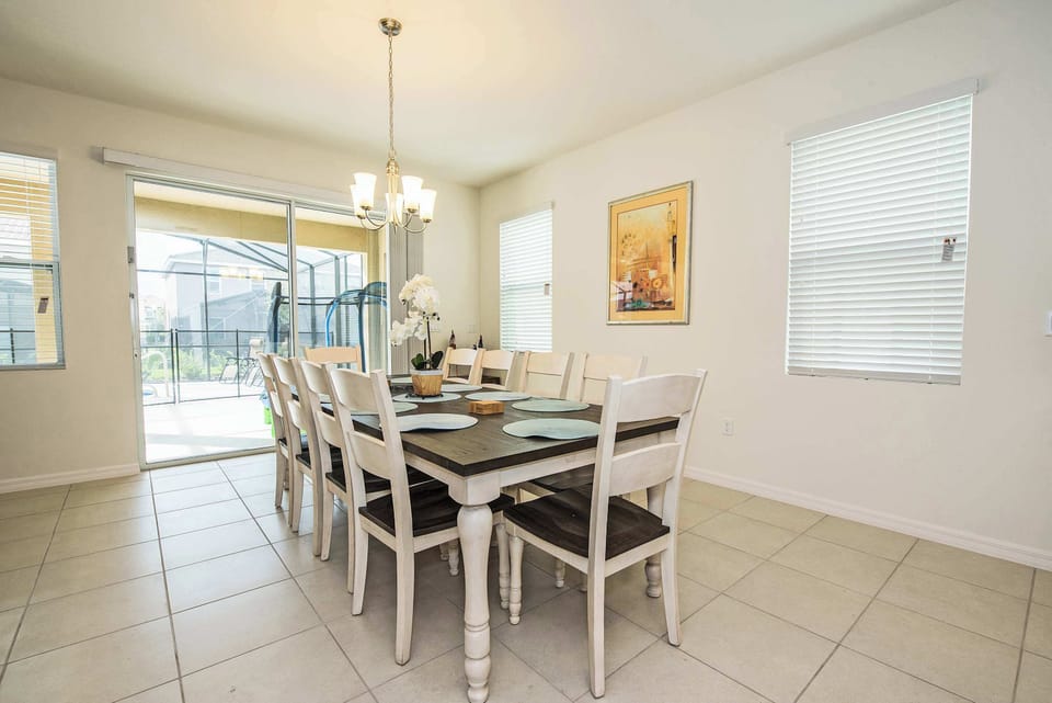 Elegant dining area with seating for ten, perfect for family gatherings and meals with a view of the patio.