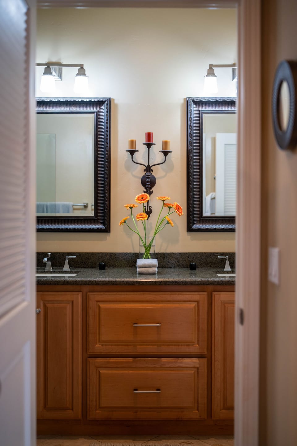 Dual vanity, terry cloth robes, granite counter, natural travertine floor tile.