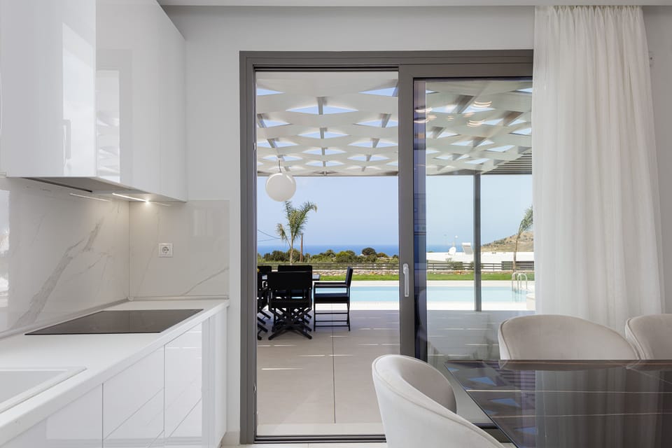 The kitchen has direct access to the outdoor dining area and pool grounds.