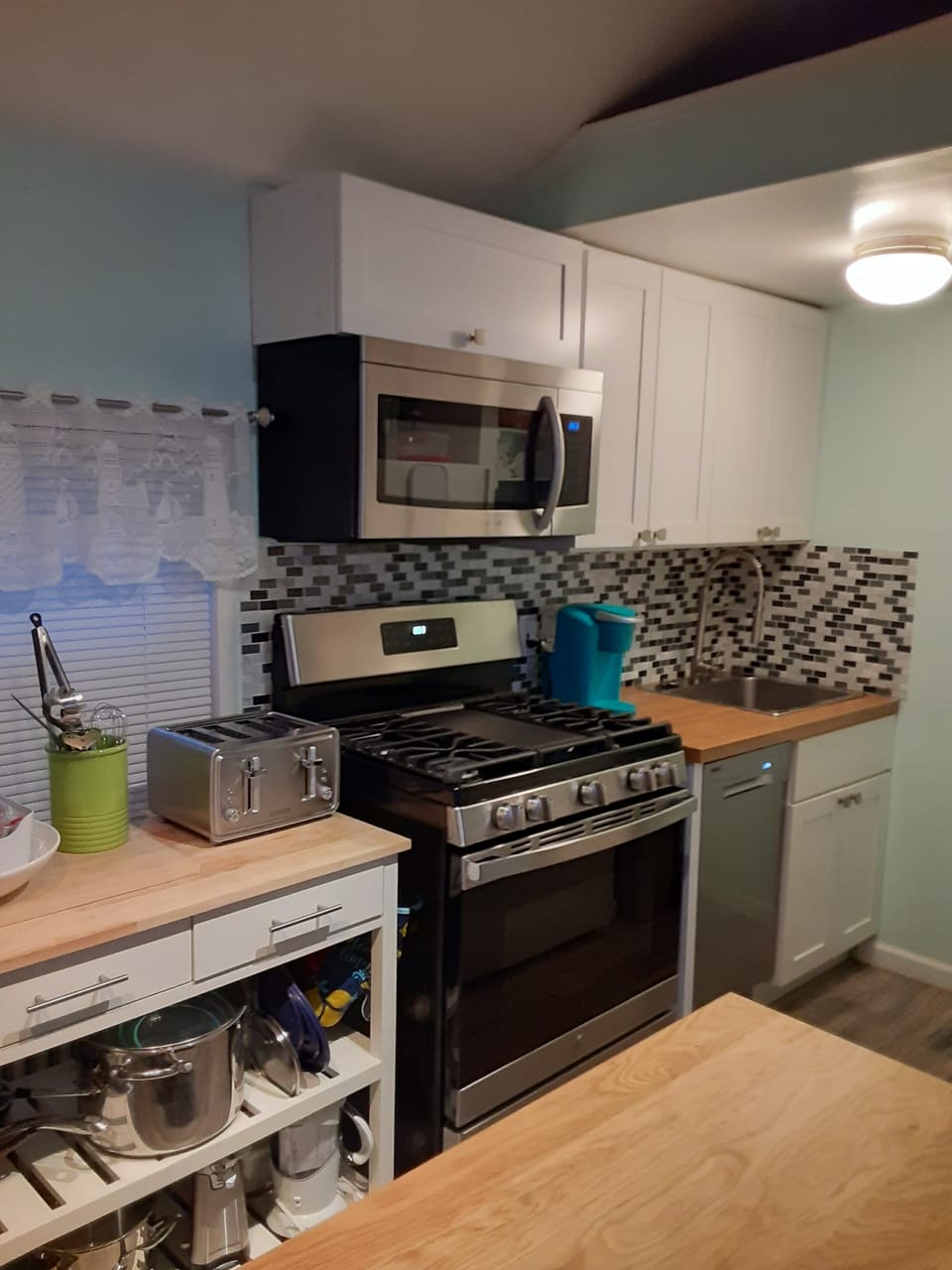 Kitchen with plenty of workspace. Gas range, microwave, dish washer, and fridge.
