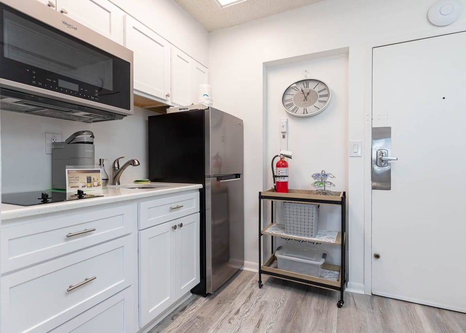 The kitchen features white cabinets, stainless appliances, and a convenient wet bar area for a delightful cooking experience