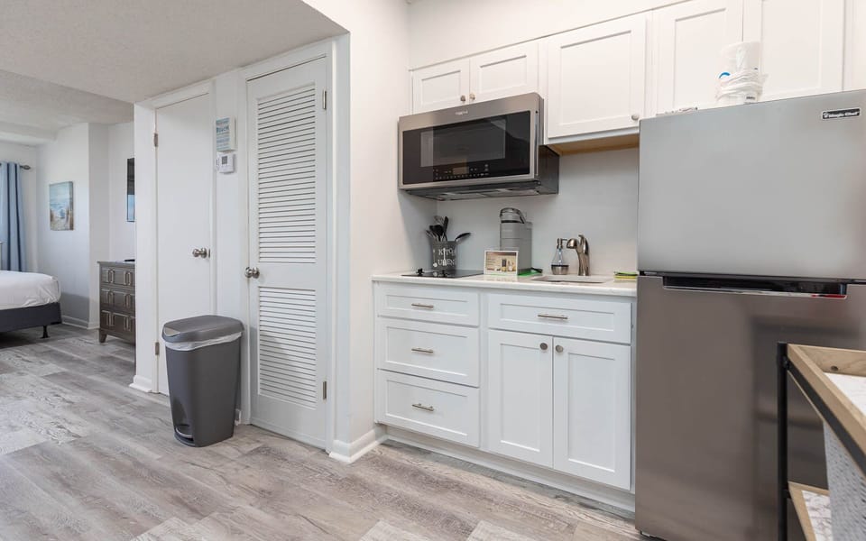 The kitchen features sleek white cabinetry, stainless appliances, and a convenient layout for preparing meals