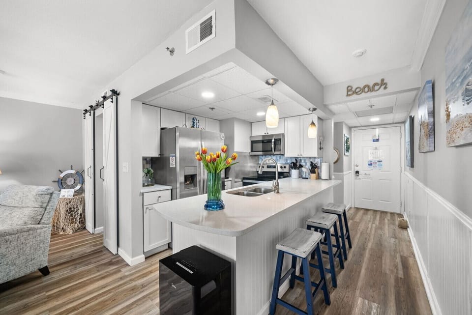 Spacious open-concept kitchen with a long breakfast bar and modern appliances perfect for cooking together.