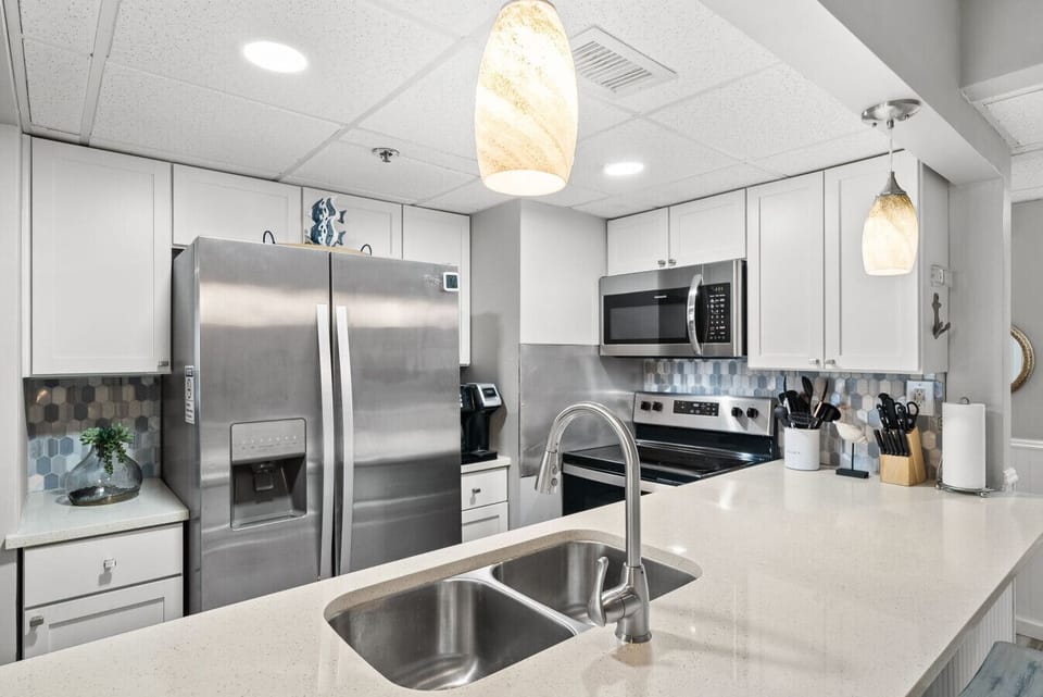 Fully equipped modern kitchen featuring stainless steel appliances and ample prep space.