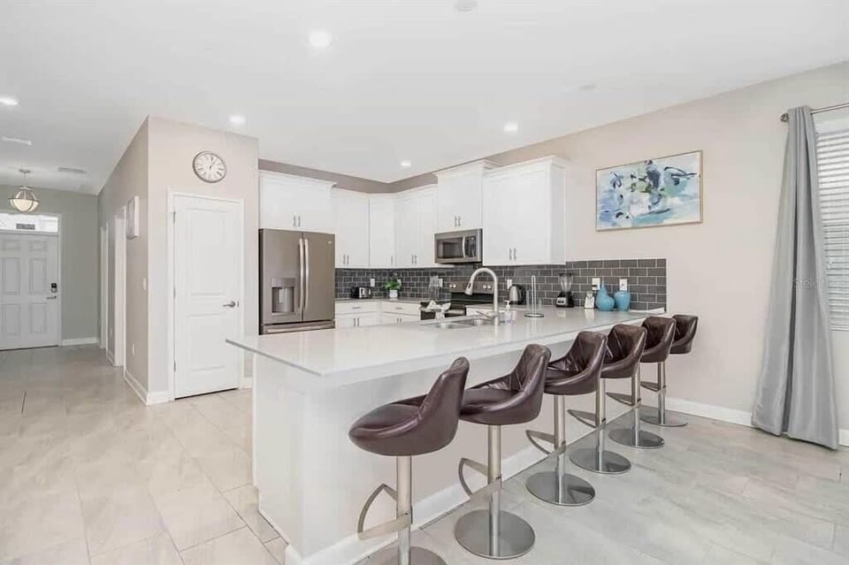 Bright and modern kitchen with a spacious island and sleek seating, perfect for culinary gatherings and entertaining.