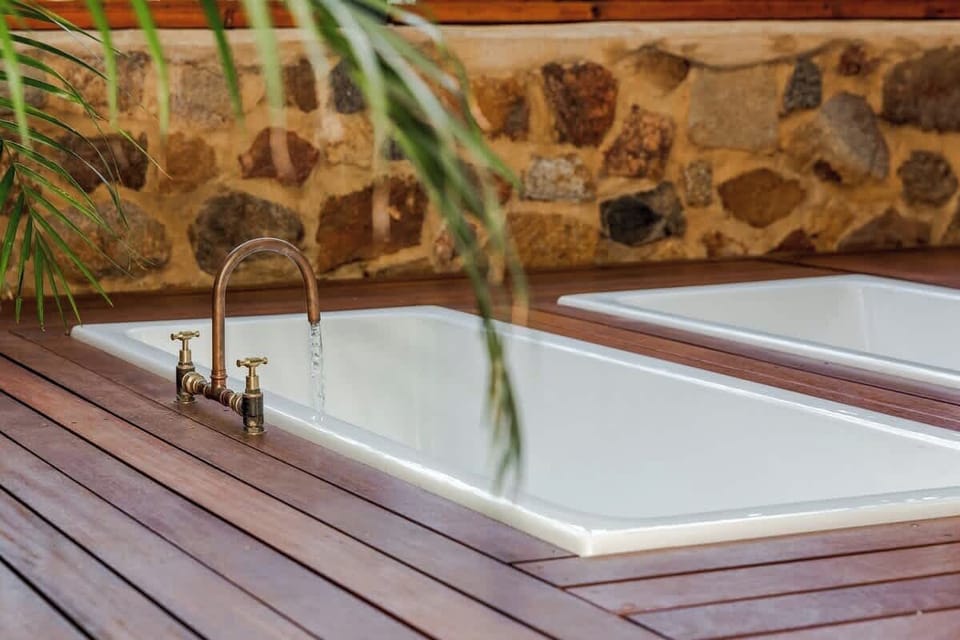 Sink into the ultimate outdoor soak with two freestanding baths nestled among greenery and twinkling lights.