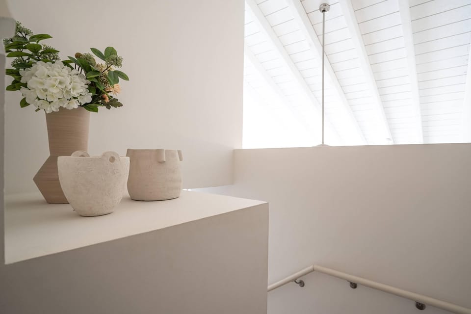 Serene minimalist design welcomes you with soft natural light filtering through vaulted ceilings, creating a peaceful atmosphere that invites relaxation and tranquility throughout your stay.