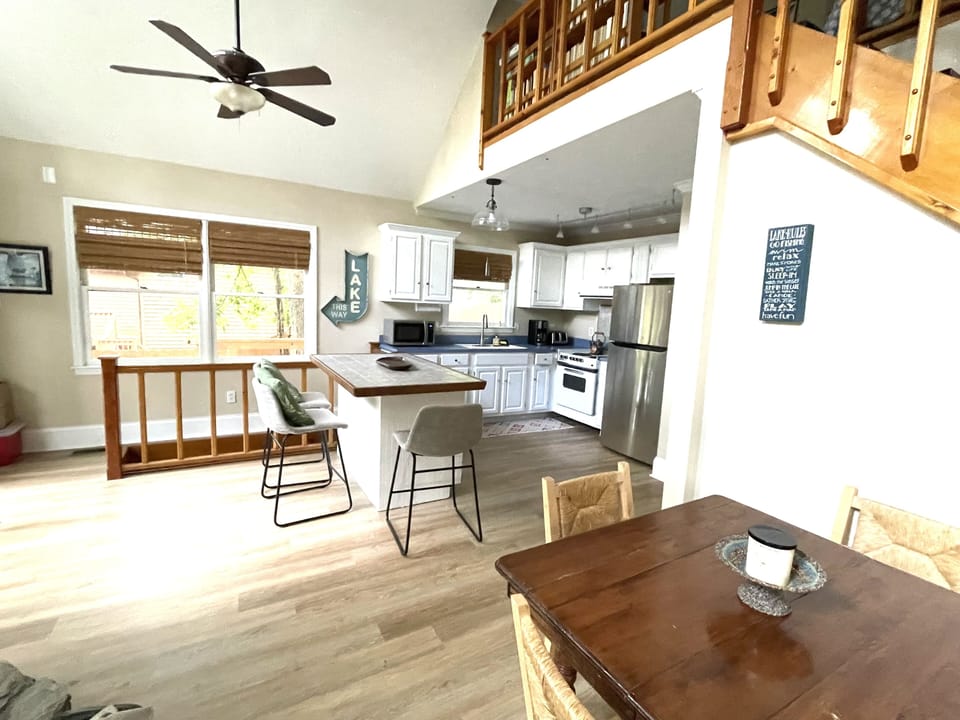 Main floor dining lounge with steps down to living room & steps up to loft