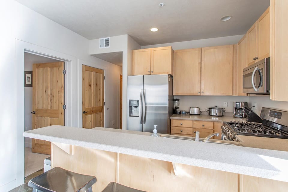 Fully equipped kitchen with stainless steel appliances and counter seating