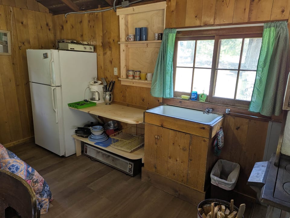 Cabin 3 is a cozy rustic cabin that features a wood-burning stove.
