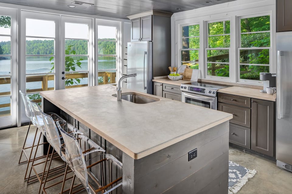 Open kitchen with extensive views of lake and four counter stools. 