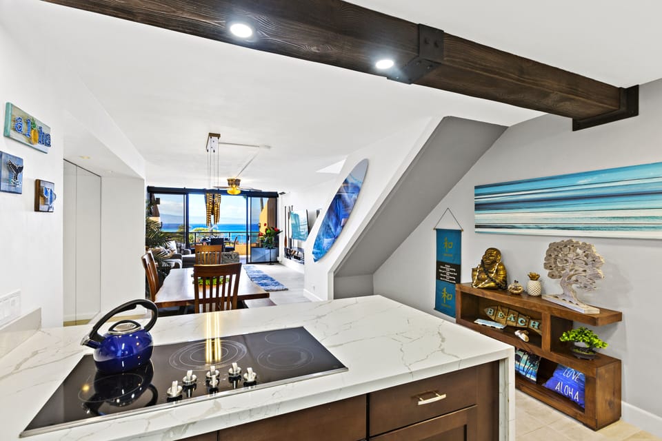 Enjoy a fully stocked kitchen with stylish decor, modern lighting, and an ocean view from the breakfast bar—perfect for preparing meals in paradise.