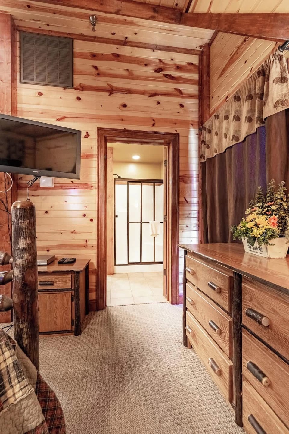 Our second floor bedroom is attached to the second floor bath and includes a mounted TV and a dresser to store your clothes during your stay!