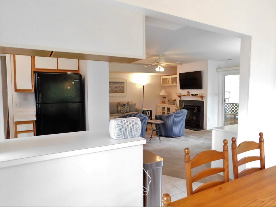 541D Hudson Avenue - Bright Open Kitchen and Dining - A view looking across the clean white kitchen countertops with a handy breakfast bar towards the dining area. The perspective showcases the bright, open-concept design that connects the culinary and dining spaces.