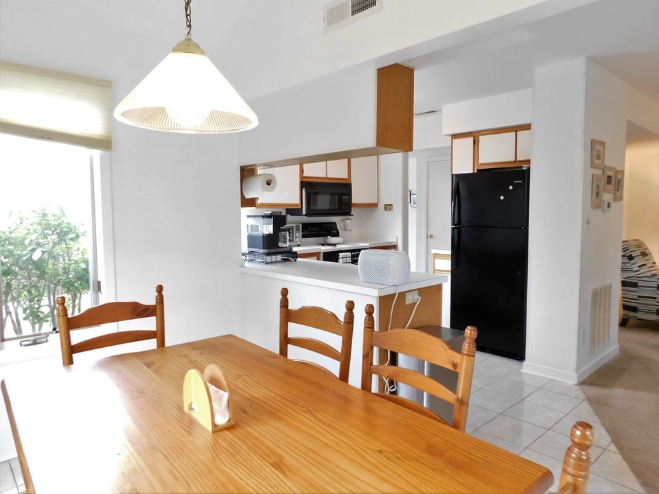 541D Hudson Avenue - Kitchen and Dining Overview - A bright and airy open-concept space featuring a white galley-style kitchen with a convenient pass-through breakfast bar that overlooks the formal dining area