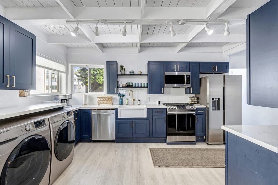 Modern kitchen w/ blue cabinetry, stainless appliances & generous counter space.