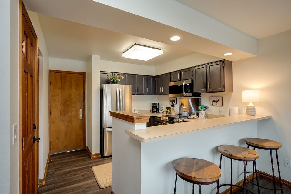 Your fully equipped kitchen features modern appliances, granite counters, and a breakfast bar where you can enjoy morning coffee.