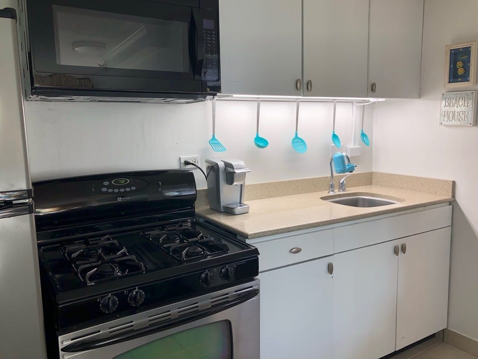 Full kitchen stocked with dishes as well as toaster, coffee pot and rice pot.