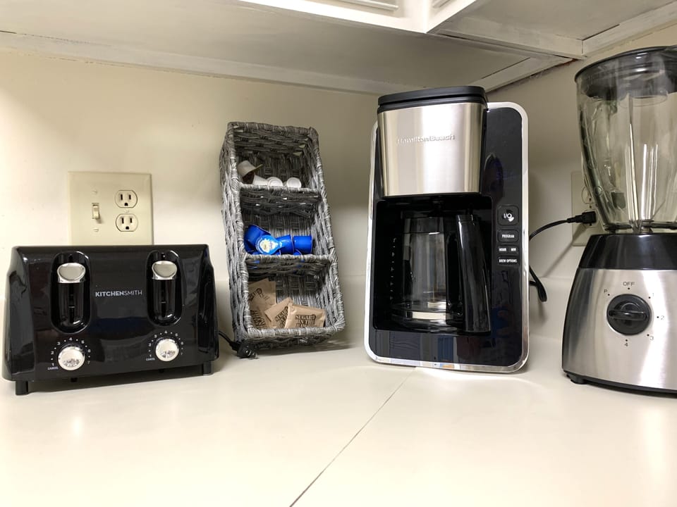 Toaster, coffee creamers, sweetener, coffee maker, & blender provided.
