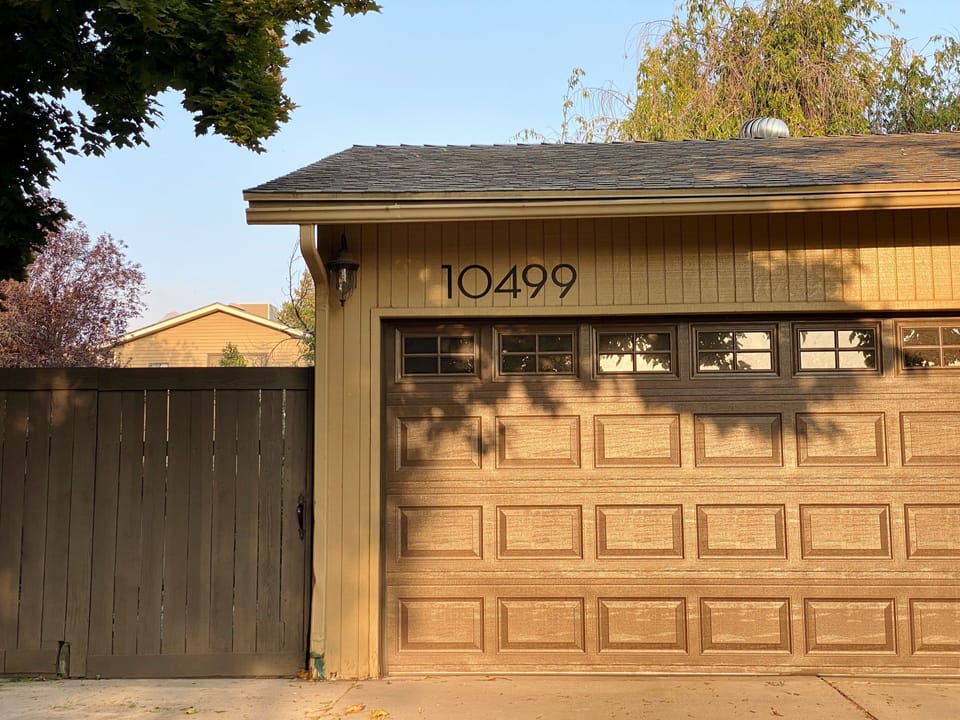 Parking on driveway in front of the brown wooden fence (left side of this photo)