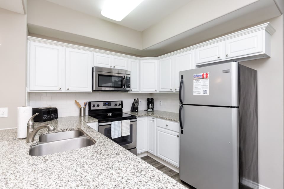 Fully equipped kitchen with stainless steel appliances and 12-cup coffee maker