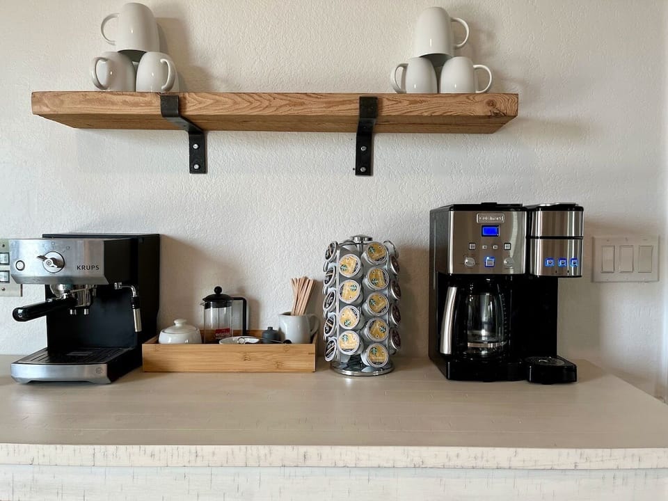 Coffee bar with espresso machine, coffee and Keurig maker, and French press. 